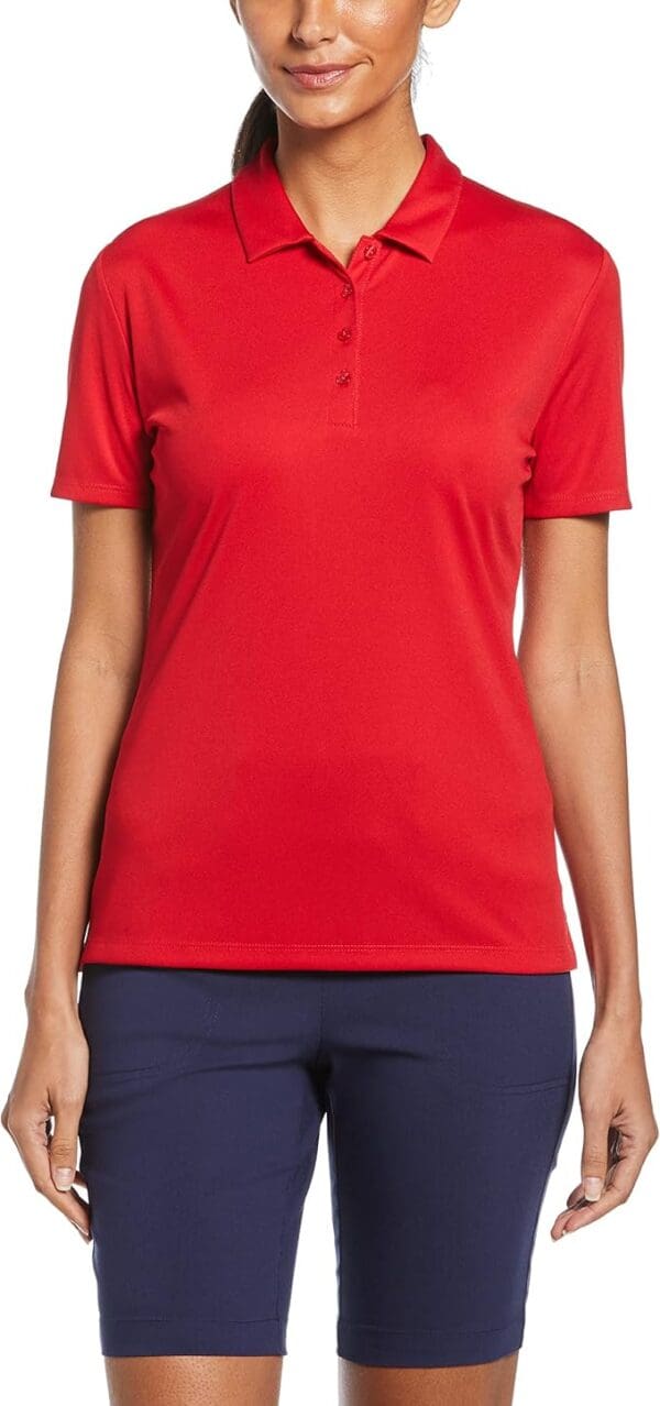 Woman wearing red polo shirt and navy shorts