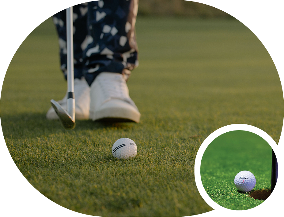 Golf ball and club on green near golfer